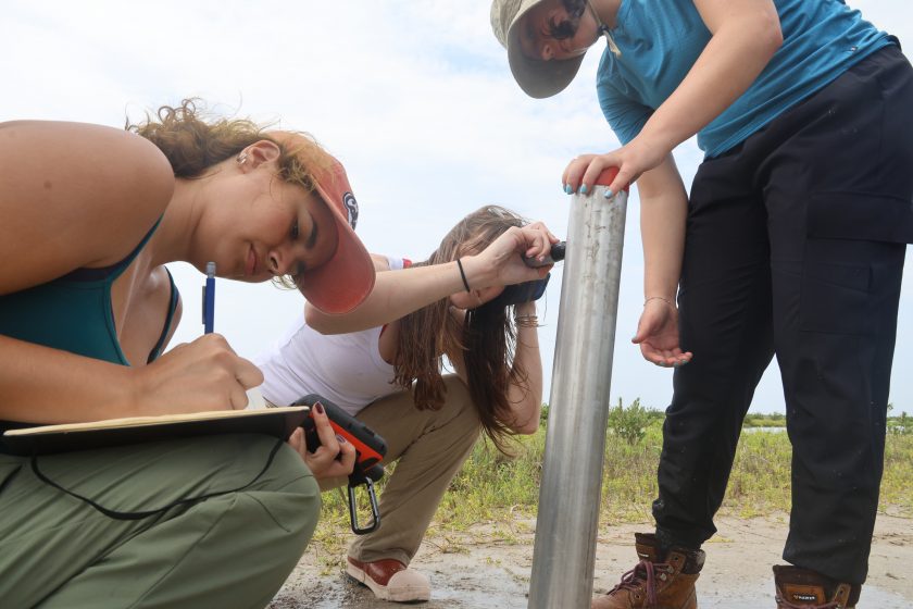 Jackson School of Geosciences senior Camilla Barreiro records GPS coordinates after helping fellow Marine Geology and Geophysics classmates collect a core sample on Harbor Island in Port Aransas, TX.
