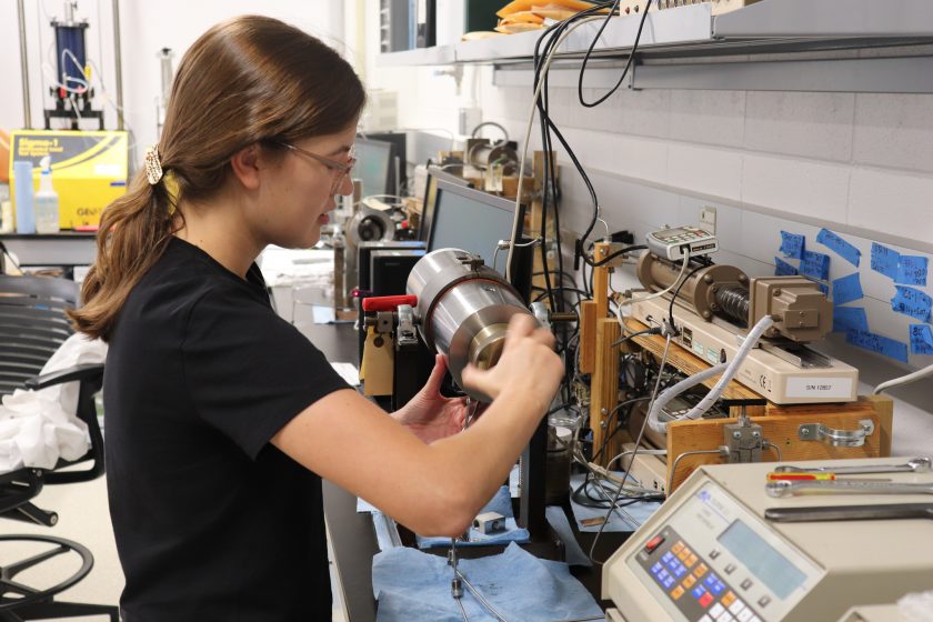 Caroline is working on a cylindrical instrument in the lab.