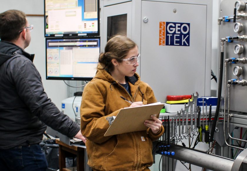 Addison records lab measurements on a clipboard in the lab