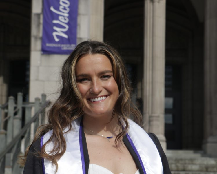 Photo of Nicole Ferrie wearing University if Washington graduation gowns.
