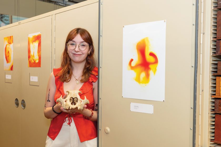 Isabelle Milford with her artwork and a fossil skull.
