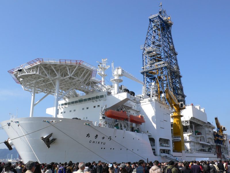 A crowd has gathered around the docked boat.