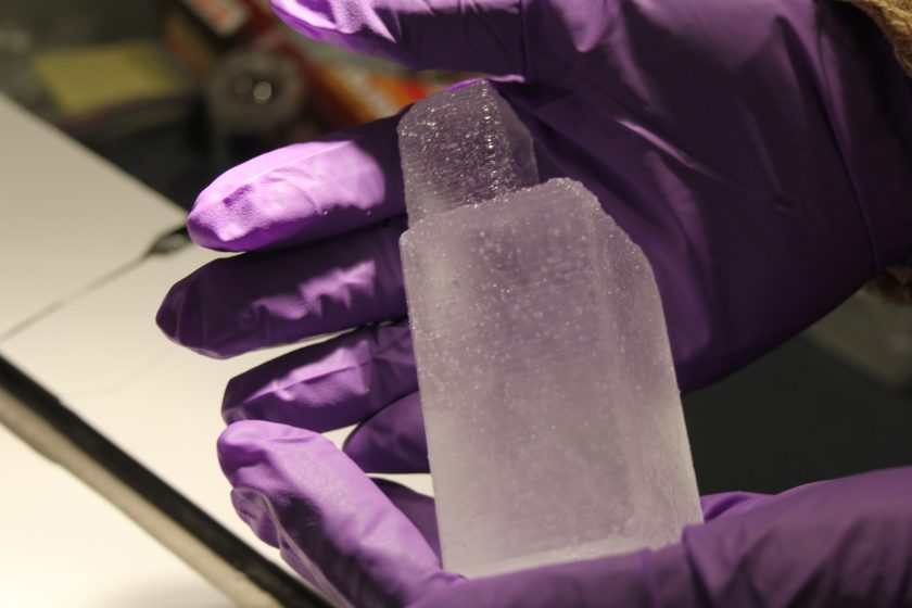 Gloved hands holding a chunk of ice