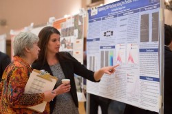 Kelly Regimbal shows her award-winning poster to  JSG Dean Sharon Mosher.