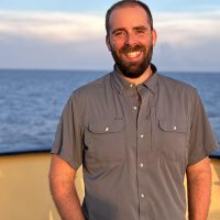 Portrait photo of Chris on the deck of a ship