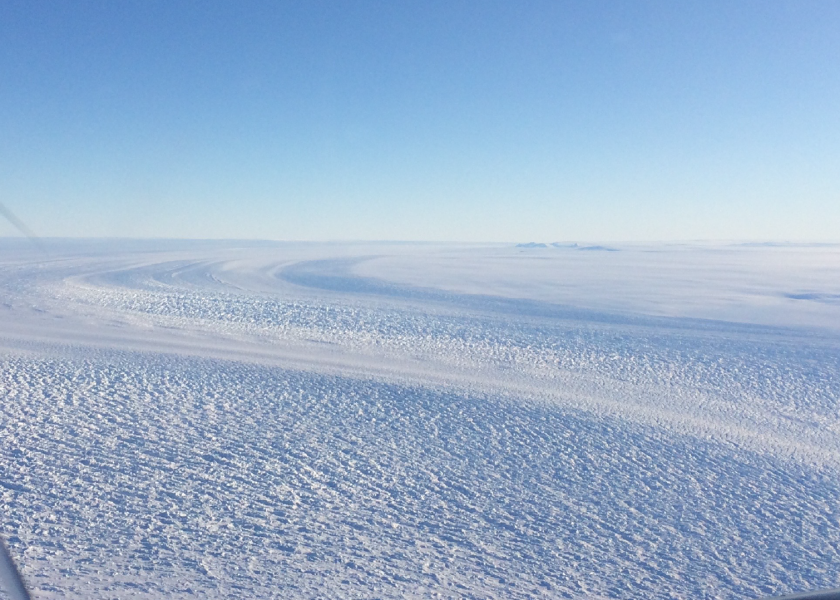 Photo of an ice sheet from high altitude. The ice extends unbroken to the horizon.