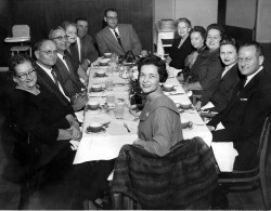 Jack and Katie seated at the heads of the table enjoying a dinner party with family.