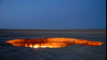 A person stands on the edge of the Door to Hell. Nick Hannes.