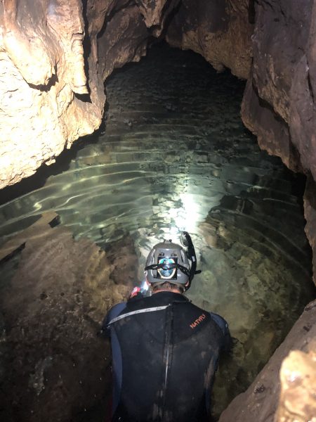 Paleontologist John Moretti snorkels in the shallow stream that flows through the water cave
