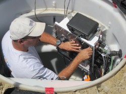 Engineer secures waterproof enclosure for seismic station electronics