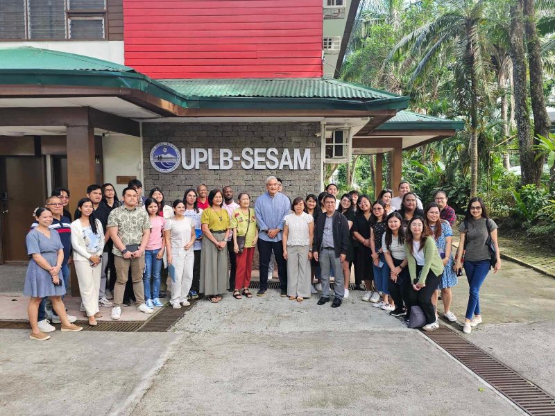 A group of people stand outside the University of Philippines Los Baños School of Environmental Science and Management. Cardenas is standing in the center wearing a light blue shirt.