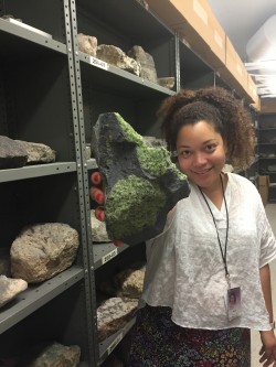 Ph.D. student Rachel Bernard holds a xenolith with green olivine grains.