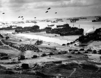 LSTs (Landing Ship Tanks), landing vehicles, and cargo on a Normandy beach, June 1944. Source: U.S. Navy.