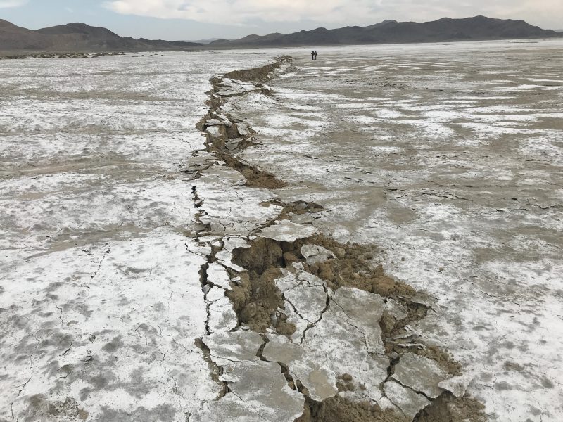 A crack in the Earth runs through a flat landscape