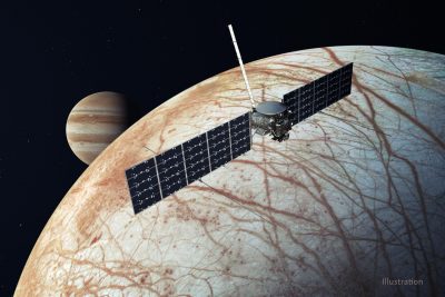 A space probe with solar panels extended over the criss-crossed surface of Europa. Jupiter rises on the horizon.