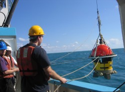 Team members deploy an ocean bottom seismometer.