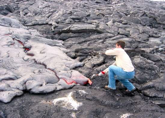 Lead author Matthew Jackson samples Hawaiian lava with a rock hammer. Credit: WHOI Geodynamics Program