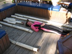 Graduate student Hali Kilbourne lays next to coral cores for length comparison. See larger image.