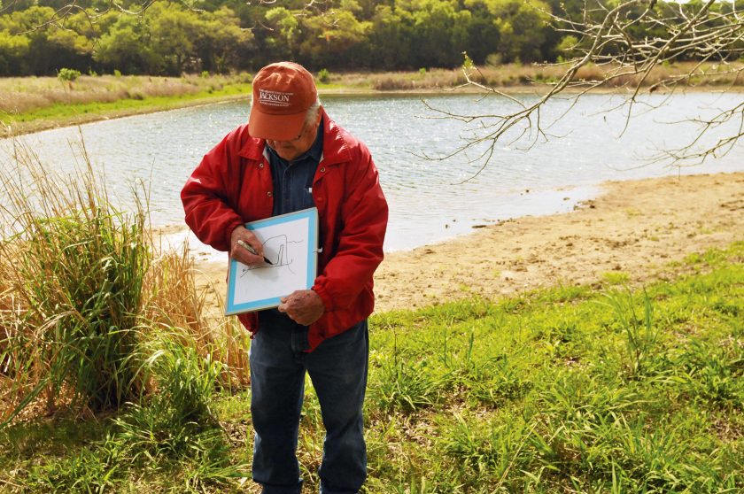 Leslie P. White explaining the hydrology of one of the ponds he built on the property.